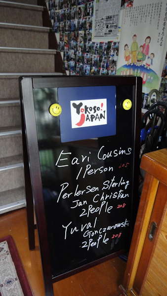 an a-frame sign with the Yokoso Japan logo and several people's names,including Eari Cousins